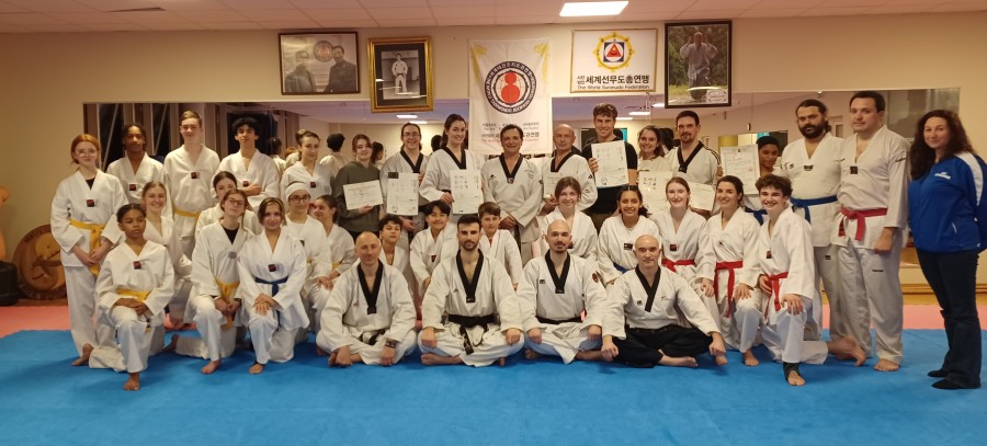 Les élèves du cours de taekwondo avec les ceintures noires qui ont reçu leur dan